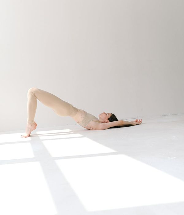 Woman in a calm yoga pose in a room with natural light.